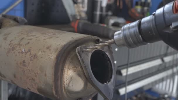 在汽车加油站钻探金属的过程 钻具在排气系统的一个很大的金属部分打了一个深孔 在车间里用机械工具钻金属制品 — 图库视频影像