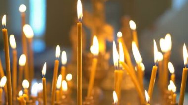 Kuma yerleştirilmiş mumlar tapınakta yanan mumlar bulanık arka plana ışık saçıyor. Hıristiyan kilisesinde ibadet gelenekleri