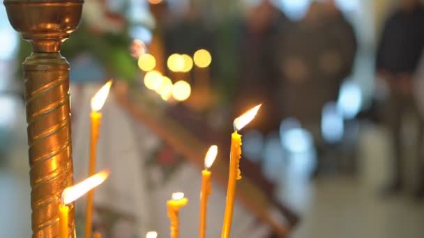 背景にぼやけた光を広げる寺院の砂の燃焼に挿入された照明ワックスキャンドル キリスト教会での礼拝の伝統について詳しく見る ストック映像