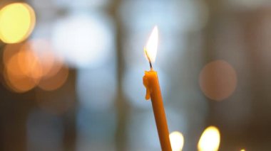 Kuma yerleştirilmiş mumlar tapınakta yanan mumlar bulanık arka plana ışık saçıyor. Hıristiyan kilisesinde ibadet gelenekleri