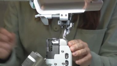 Atölyedeki bir masada deri kesen bir ayakkabıcının yakın çekimi. Dişi bir terzi deri parçalarında izler bırakır ve ayakkabı yapmak için bir bıçakla kuru sıkı hazırlar. Ayakkabı yapma süreci