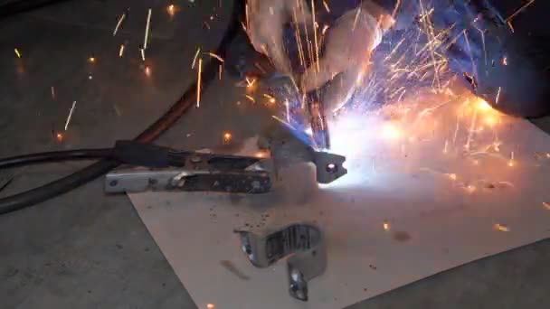 带防护面罩的焊机和手套用焊机在特殊桌子上焊接金属零件 车间内金属零件焊接工艺的闭合 — 图库视频影像