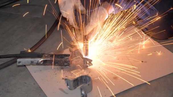 带防护面罩的焊机和手套用焊机在特殊桌子上焊接金属零件 车间内金属零件焊接工艺的闭合 — 图库视频影像