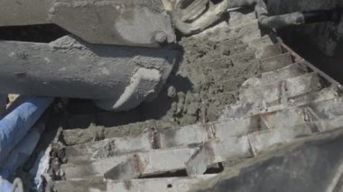 İnşaat alanındaki inşaatçılar yüzeyi beton ve küçük çakıl karışımıyla bir konut inşaatı alanının betonlaşması için döşüyorlar.