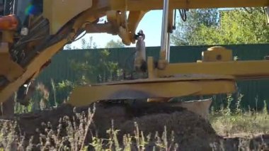 Büyük, güçlü bir buldozer inşaat alanında çalışmak için alanı temizliyor.