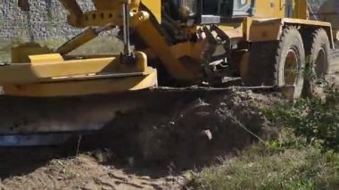 Büyük, güçlü bir buldozer inşaat alanında çalışmak için alanı temizliyor.