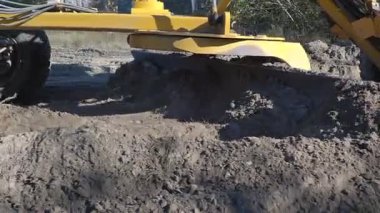 Büyük, güçlü bir buldozer inşaat alanında çalışmak için alanı temizliyor.