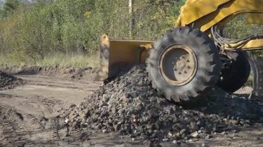 Büyük, güçlü bir buldozer inşaat alanında çalışmak için alanı temizliyor.