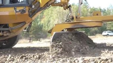 Büyük, güçlü bir buldozer inşaat alanında çalışmak için alanı temizliyor.