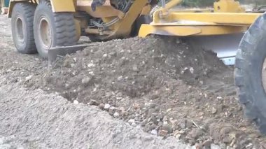 Büyük, güçlü bir buldozer inşaat alanında çalışmak için alanı temizliyor.