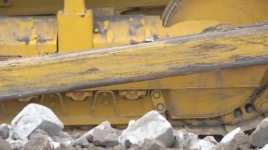 Büyük, güçlü bir buldozer inşaat alanında çalışmak için alanı temizliyor.