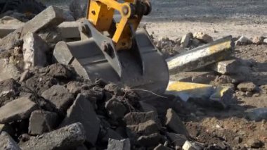 İnşaat atıklarını bir kamyonun arkasına yüklüyorlar. Büyük bir kazıcı kovası arkasına atık doldurur. Alanı boşaltıyorum..
