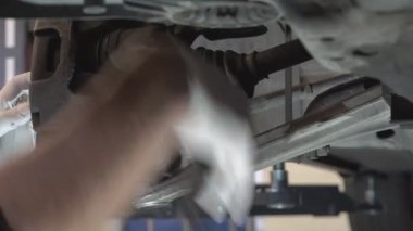 Bir araba tamircisi bir yolcu arabasının fren sistemini tamir eder. Ön kalibrenin bakımı ve fren ayakkabılarının değiştirilmesi.