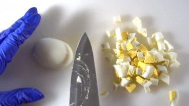 Diyet salatası hazırlamak için, haşlanmış yumurtaları bıçakla küçük parçalara ayır.