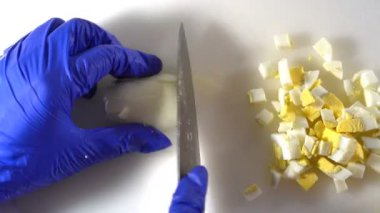 Diyet salatası hazırlamak için, haşlanmış yumurtaları bıçakla küçük parçalara ayır.