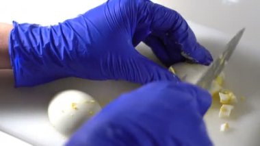 Diyet salatası hazırlamak için, haşlanmış yumurtaları bıçakla küçük parçalara ayır.