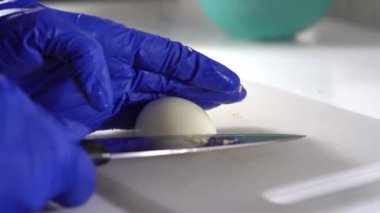 Diyet salatası hazırlamak için, haşlanmış yumurtaları bıçakla küçük parçalara ayır.