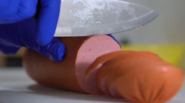 Mutfakta aşçı tabağa sosis pişirdi.