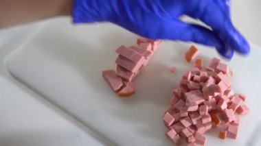 Mutfakta aşçı tabağa sosis pişirdi.