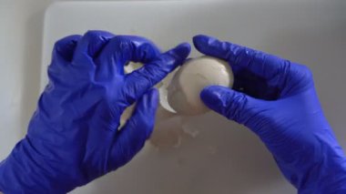 Bir aşçı haşlanmış yumurtayı kabuğundan soyar.