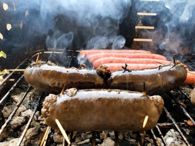 Preparando embutidos en una barbacoa