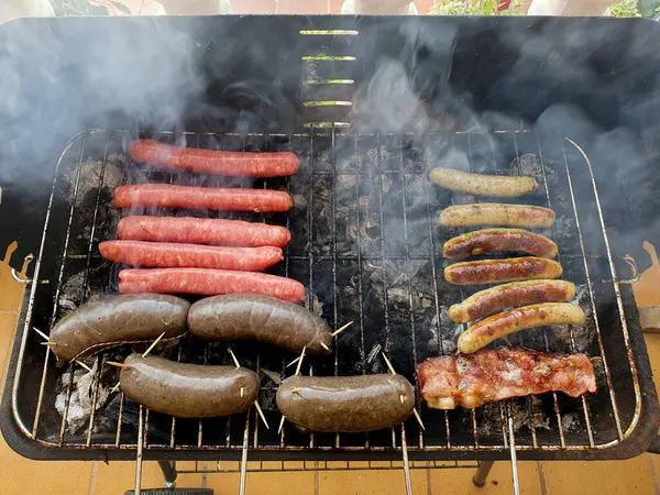 Preparando embutidos en una barbacoa