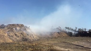 Çöplükte ya da atık sahasında yanan çöp yığını çevreye zehirli duman yayıyor ve havayı kirletiyor. Kazıcı ya da toprak taşıyıcı çöpü ayırır ya da taşır.