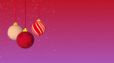 Karlı bir zeminde asılı duran Noel topları