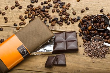 Presentation of chocolate packages of different colors on the table with coffee beans, nuts