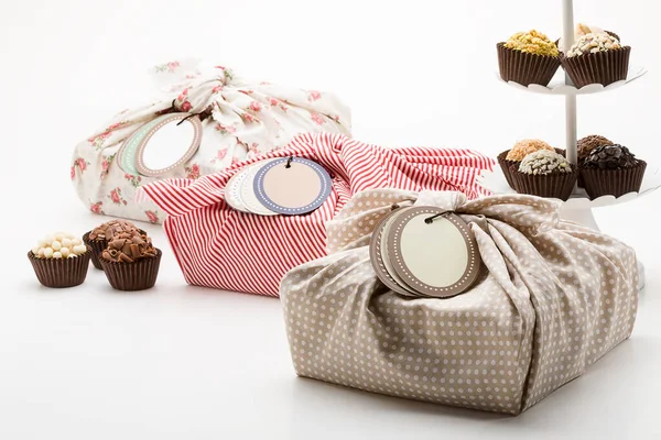 Presentation of handmade chocolates with handmade gift packages on a white background