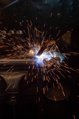 welder and machine welding in steel industry