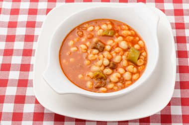Meaty baked beans dish on a white plate