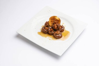 Fig dessert on a white plate, garnished with a slice of dried apple