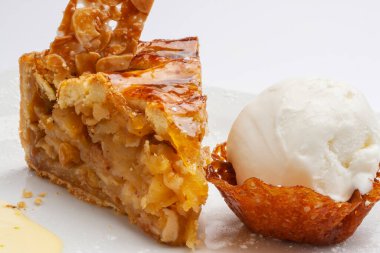 Apple pie garnished with pretzels and a scoop of ice cream on the side