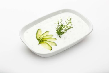 A plate of tzatziki garnished with cucumber slices