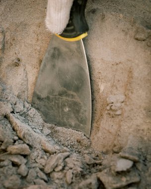 Bir arkeolojik alanın temizlenmesi (spatula ile kumun temizlenmesi))