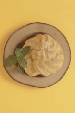 Sarı arka planda Kue Soes ya da choux la crme izole edilmiş. Mükemmel şişirilmiş ve kremalı dolgu ile dolu, bu klasik Fransız tatlısının kesinlikle zevkli olacağı kesin. Seçici Odaklanma. Yakın çekim.