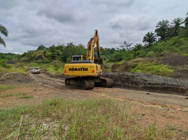 excavator is working on dirt road