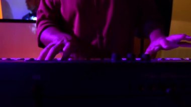 Musician playing on a synth at a party