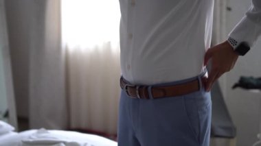 Elegant guy fixing a belt