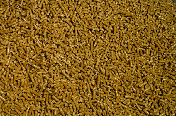 In the photograph you can see a background of pellets with bright brown colors and shadows.