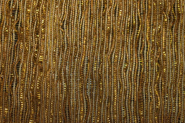 In the photograph you can see a background with brown and gold glitter making vertical waves.