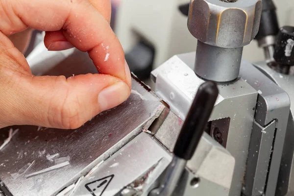 Closeup to the scientist hands working on a rotary microtome to obtain sections from a paraffin-embedded specimen.