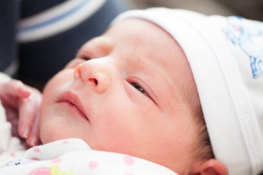 Doğduğu gün hastanede babasının kollarında yeni doğmuş bir kız.