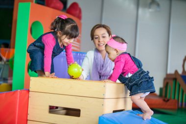 Kız kardeşler anneleriyle oynuyorlar. Bebek ve çocuk konsepti için erken uyarılma.