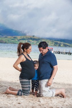 İkinci bebeklerini bekleyen genç çift, Kolombiya 'nın deniz seviyesinden 3,015 metre yükseklikteki Boyaca Bölümü' ndeki güzel beyaz Tota Gölü plajında kızlarıyla eğleniyor.