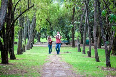 Genç ebeveynler altı aylık kızlarıyla dışarıda eğleniyorlar. Mutluluk kavramı. Aile kavramı