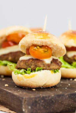 Mini hamburger servis etmeye hazır. Adım adım mini burgerleri hazırlıyorum. Çocuklar ve aperatifler için ev yapımı mini burgerler. Küçük hamburgerler..