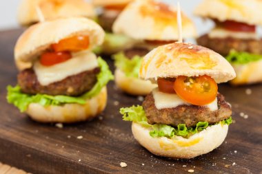 Mini hamburger servis etmeye hazır. Adım adım mini burgerleri hazırlıyorum. Çocuklar ve aperatifler için ev yapımı mini burgerler. Küçük hamburgerler..
