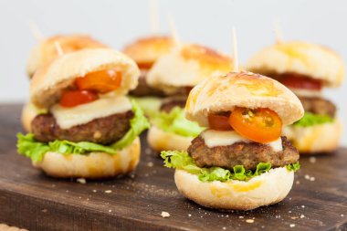 Mini hamburger servis etmeye hazır. Adım adım mini burgerleri hazırlıyorum. Çocuklar ve aperatifler için ev yapımı mini burgerler. Küçük hamburgerler..